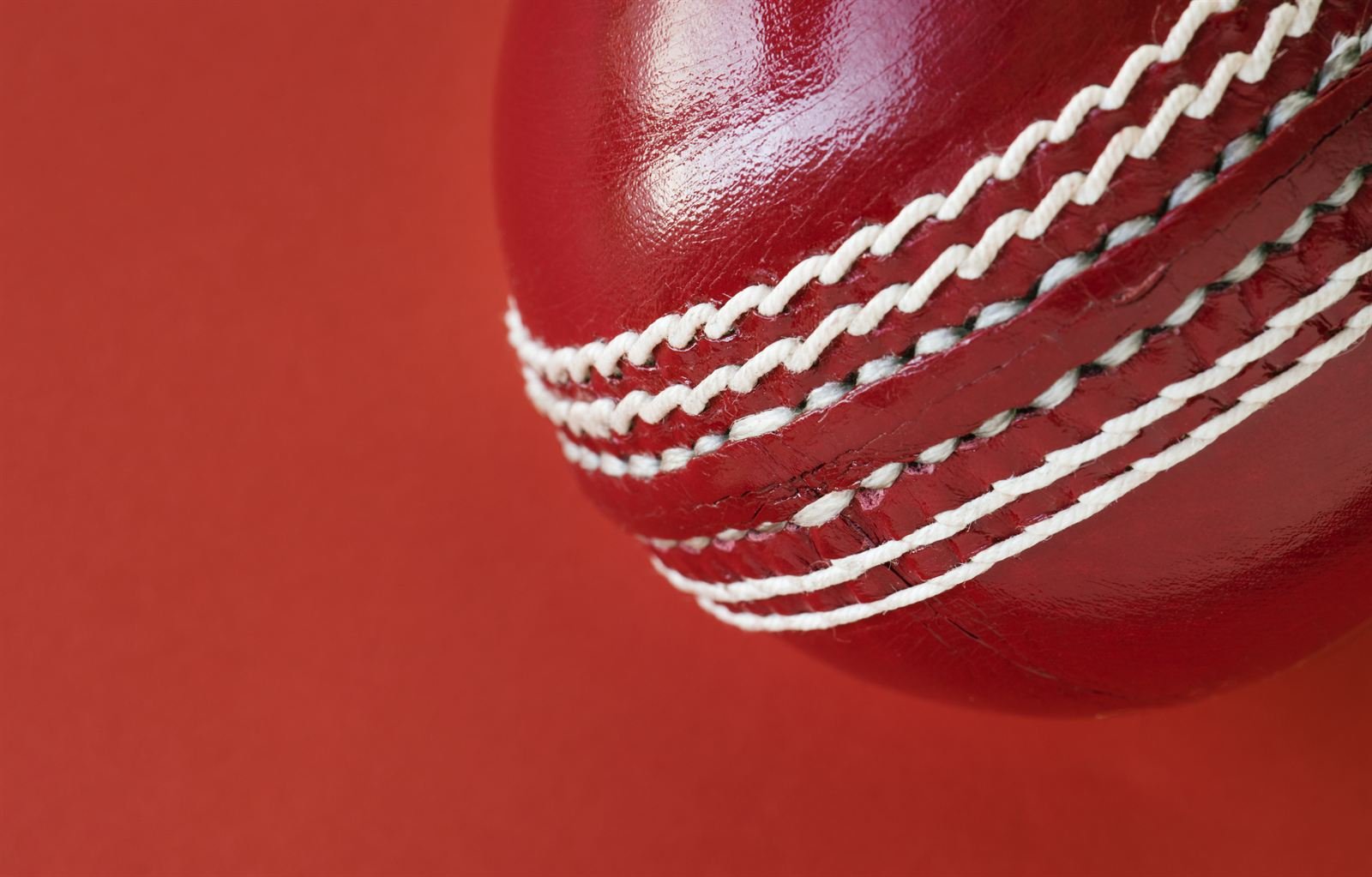 A red leather cricket ball, close up