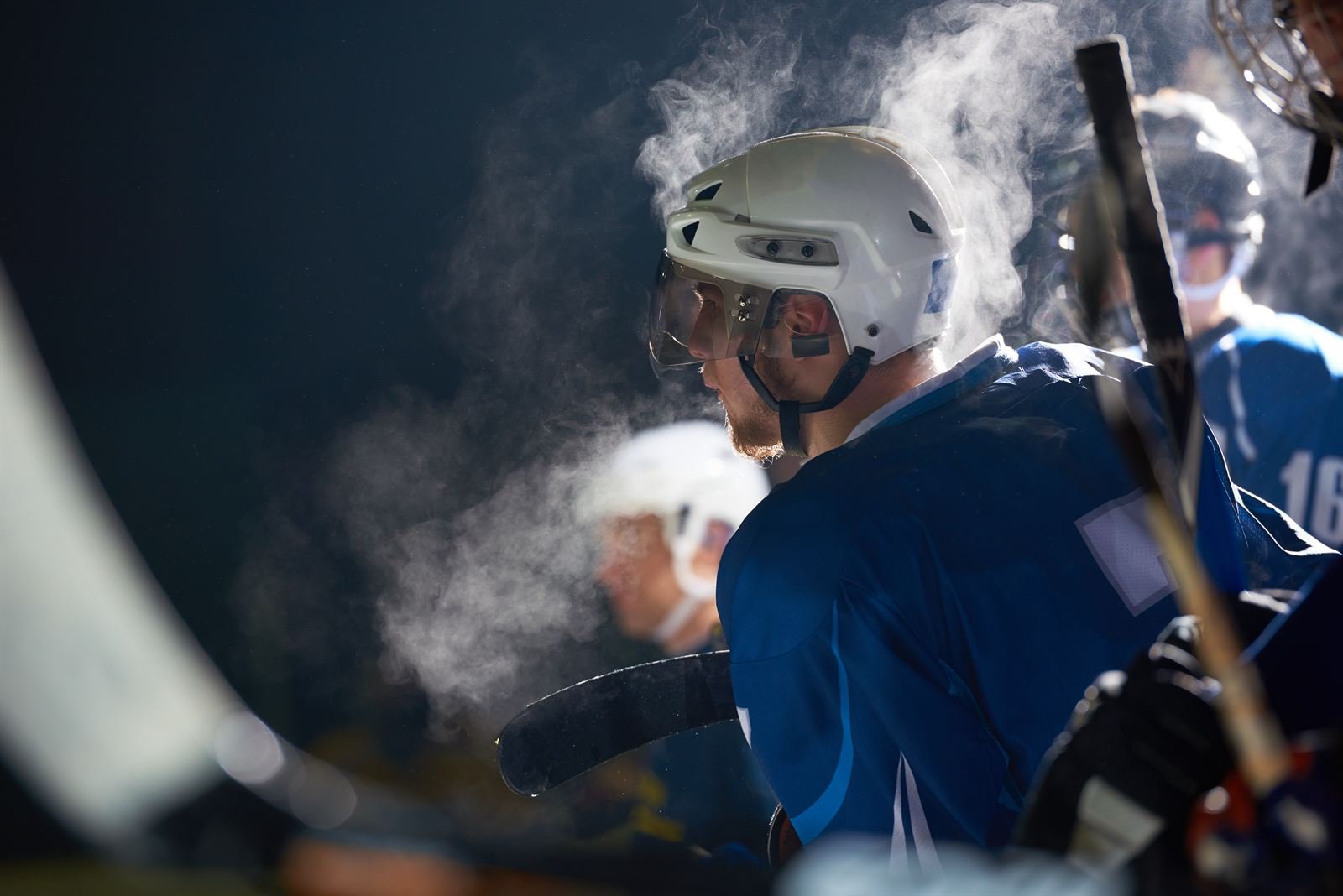 Ice hockey players on the bench, their breath visible in the cold